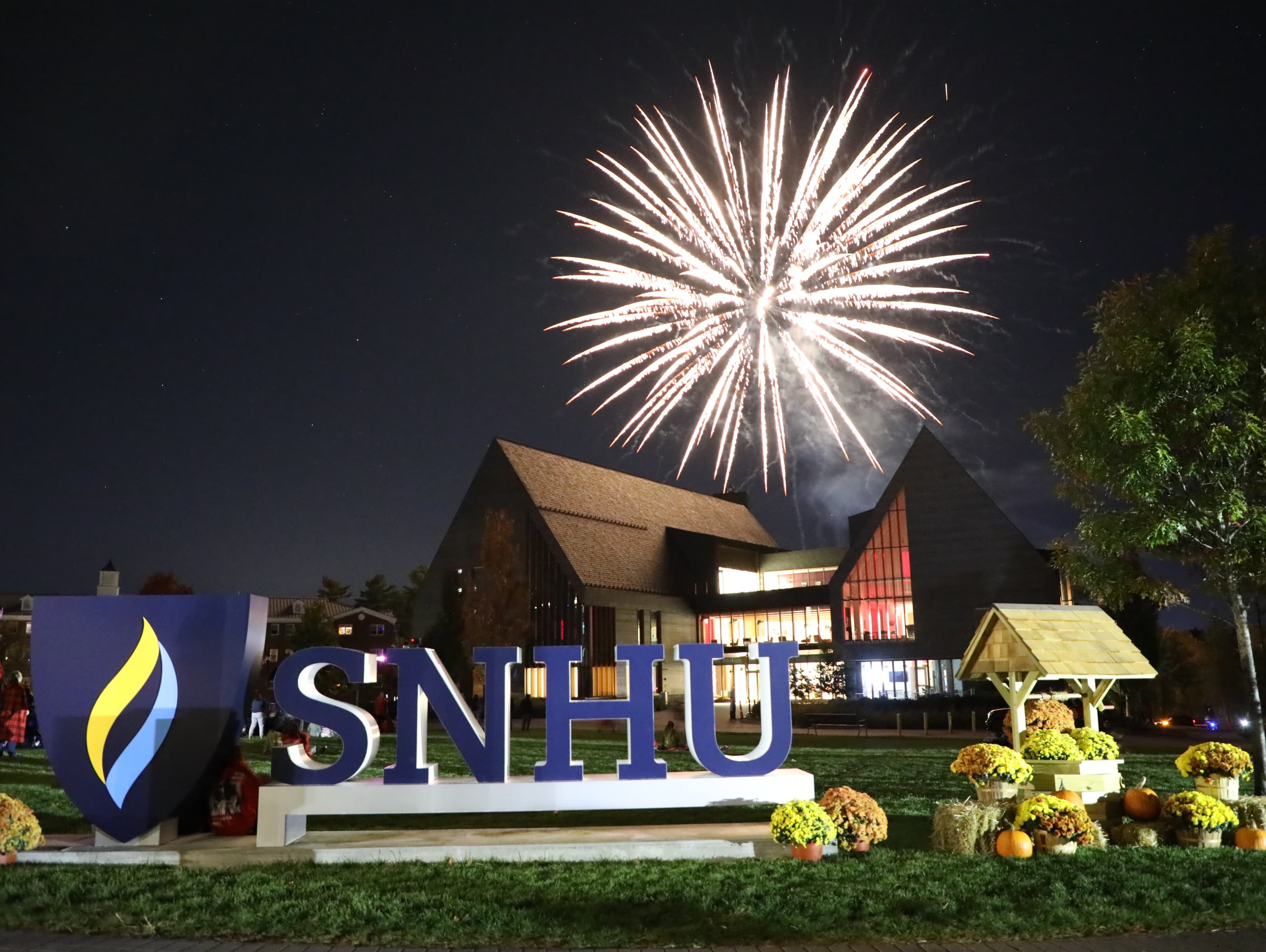 SNHU campus sign lit up with fireworks celebration